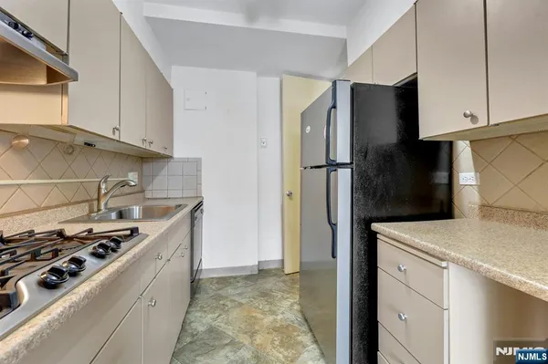 a kitchen with stainless steel appliances granite countertop a refrigerator and a stove