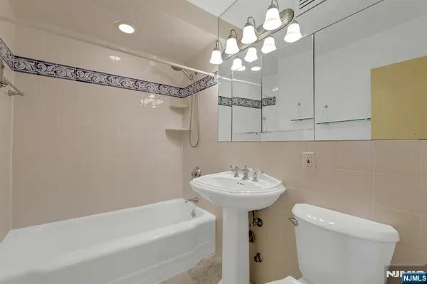 a bathroom with a sink a mirror toilet and bathtub