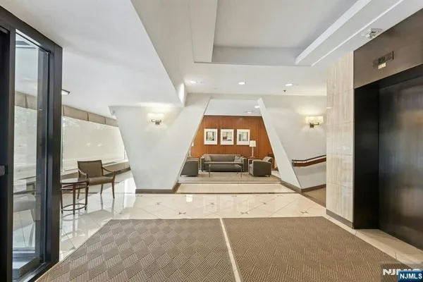a view of a hallway with a couches and dining table with wooden floor