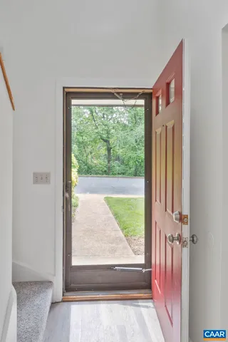 a view of a hallway with wooden floor and a bathroom