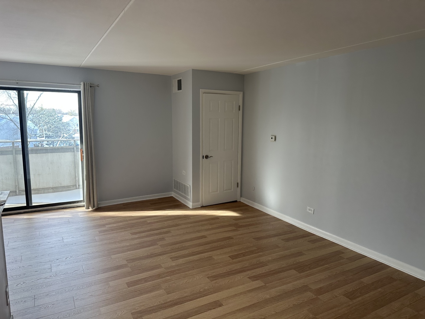 1463 Mercury Drive, Unit 304 Schaumburg, IL 60193 - Photo 5 of 13 a view of an empty room with wooden floor and a window