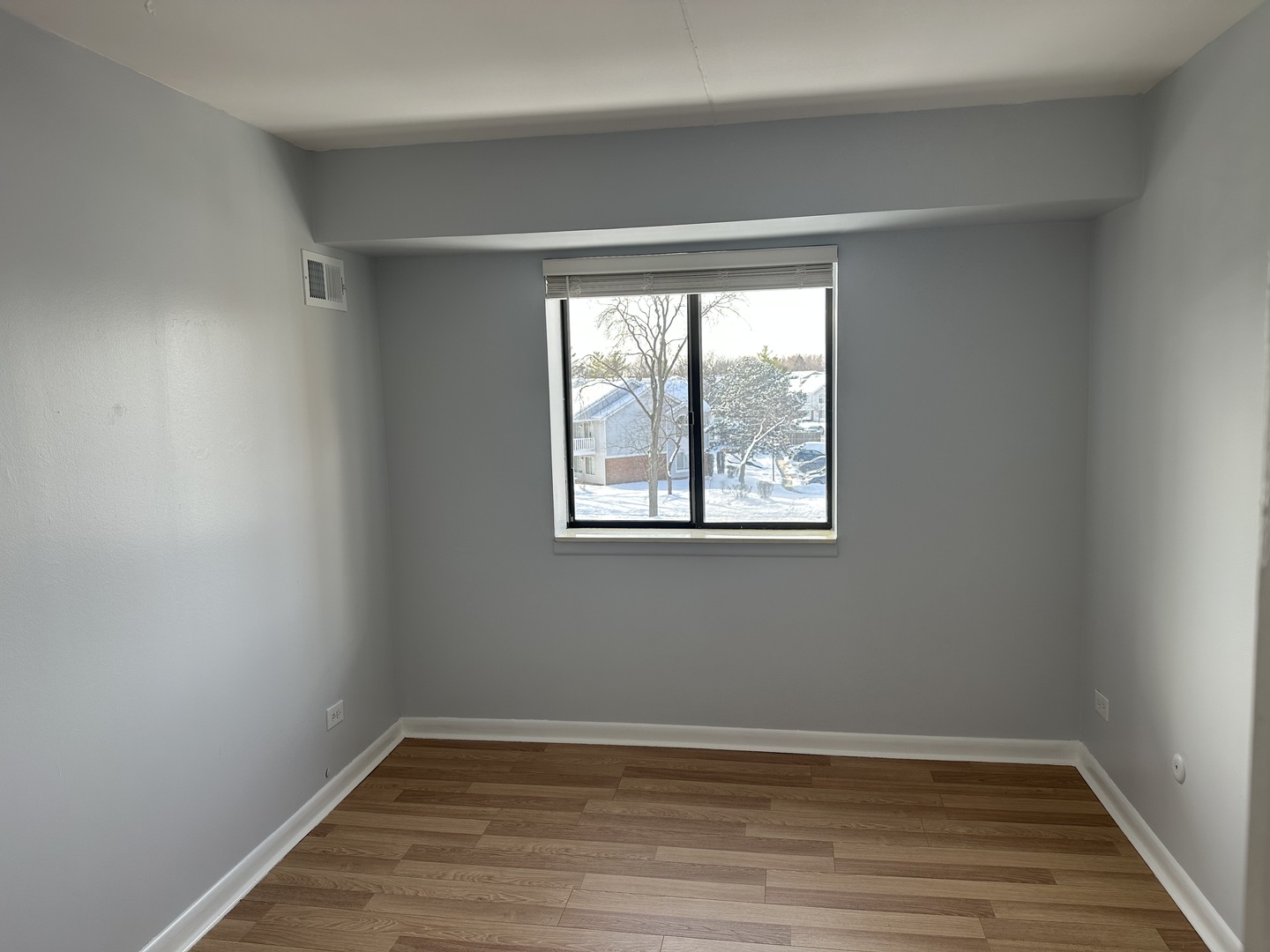 1463 Mercury Drive, Unit 304 Schaumburg, IL 60193 - Photo 9 of 13 wooden floor in an empty room with a window