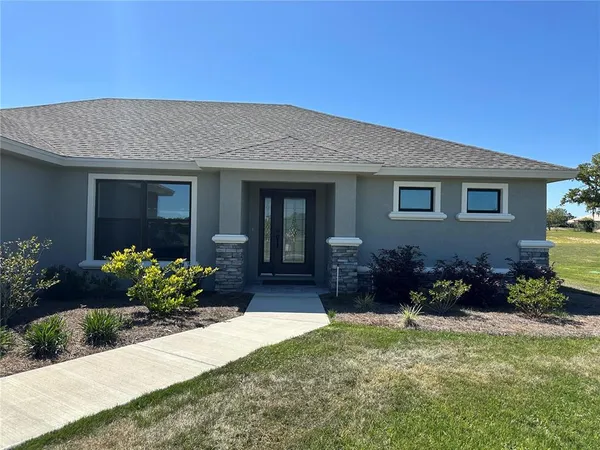 a front view of house and yard with beautiful flowers