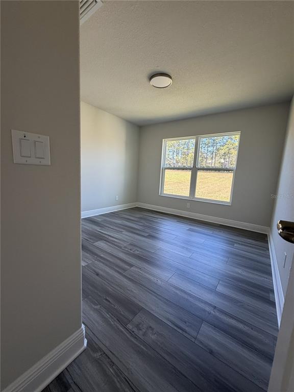 587 North Riva Ridge Path Inverness, FL 34453 - Photo 14 of 42 an empty room with wooden floor and windows