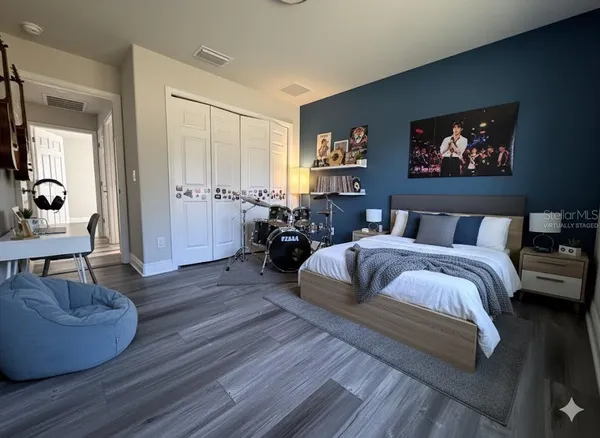 a spacious bedroom with a bed a couch and a potted plant