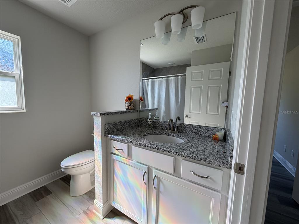 587 North Riva Ridge Path Inverness, FL 34453 - Photo 20 of 44 a bathroom with a granite countertop sink a toilet and a mirror