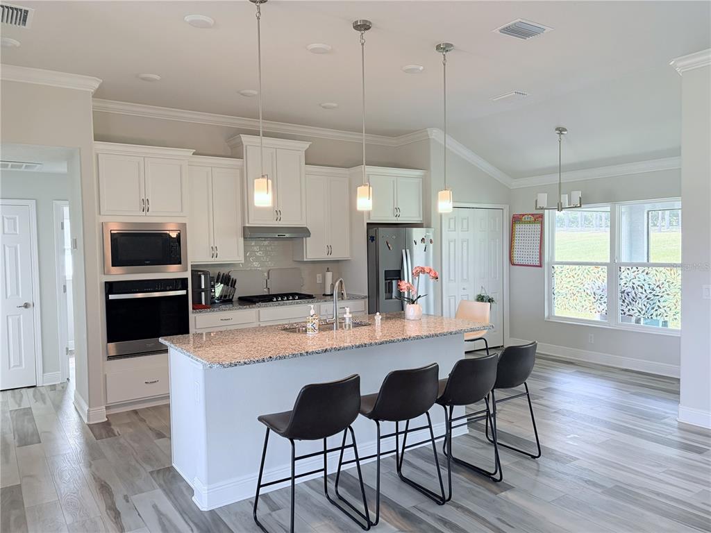 587 North Riva Ridge Path Inverness, FL 34453 - Photo 8 of 42 a kitchen with stainless steel appliances granite countertop a sink a stove a refrigerator and island with wooden floor