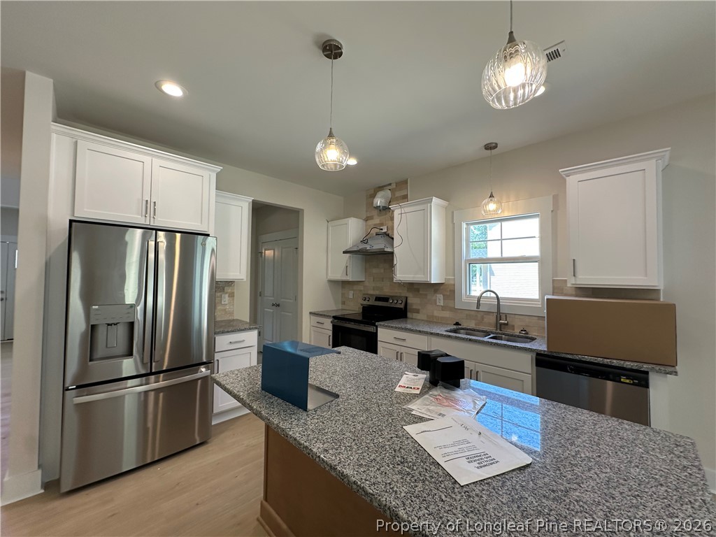 2908 Calloway Road Raeford, NC 28376 - Photo 10 of 25 a kitchen with stainless steel appliances granite countertop a sink refrigerator stove and microwave