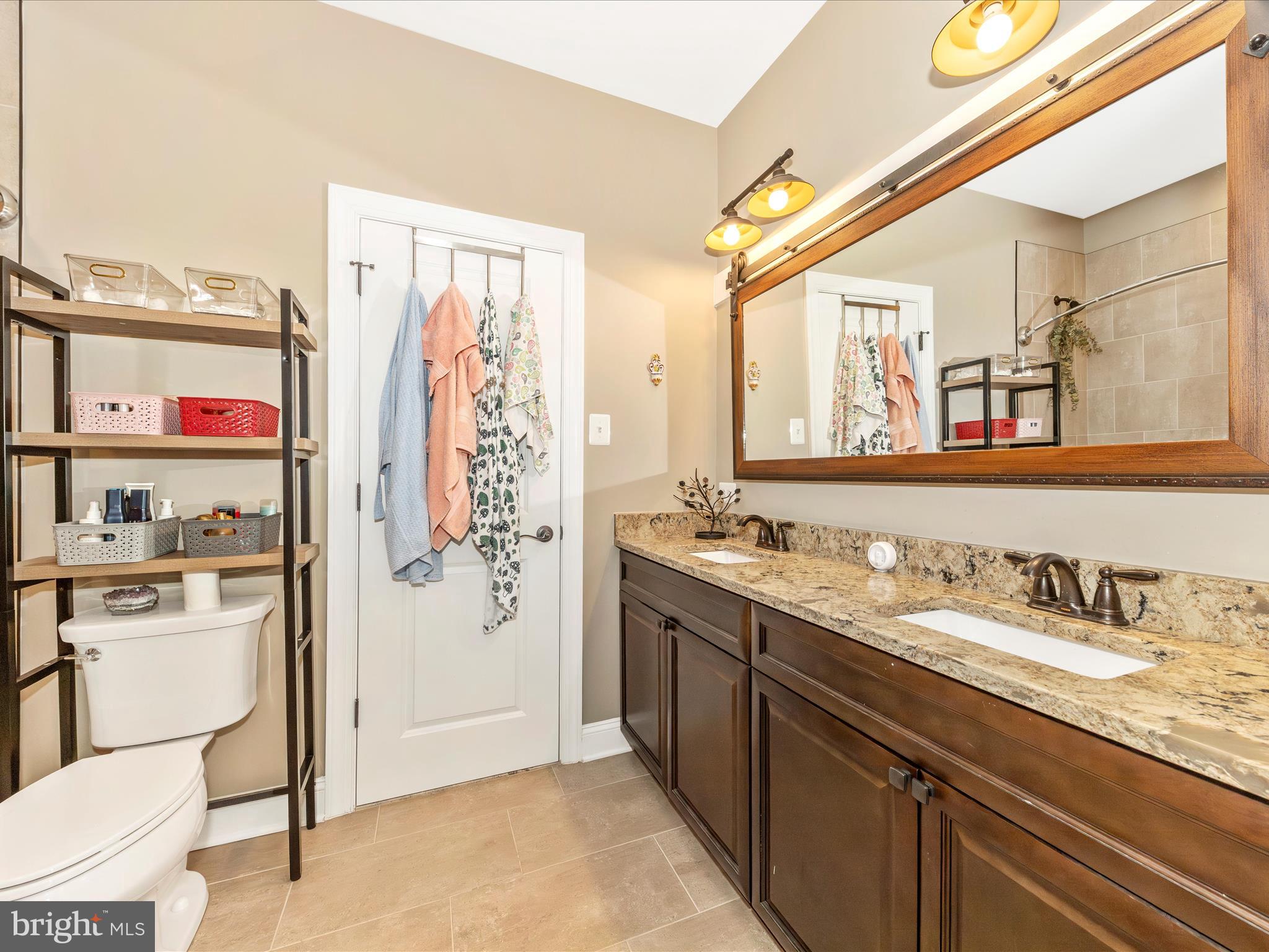 7788 Old Receiver Road Frederick, MD 21702 - Photo 31 of 51 a spacious bathroom with a granite countertop double vanity sink a mirror and a shower