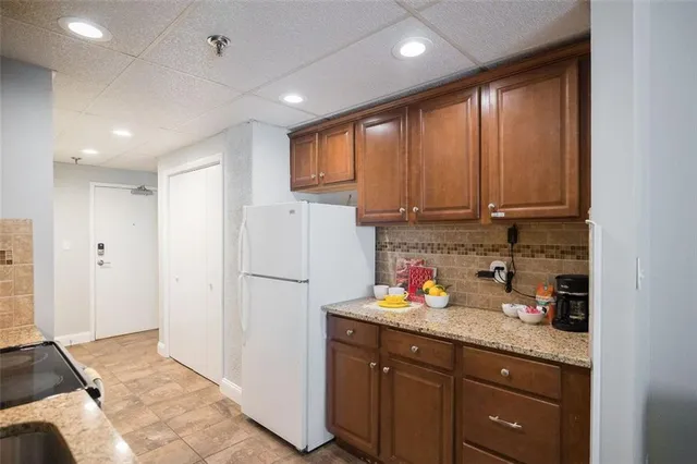 a kitchen with granite countertop wooden cabinets and white appliances