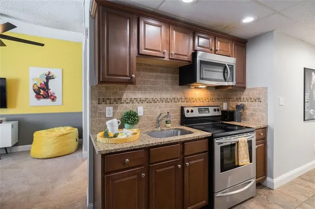 a kitchen with stainless steel appliances granite countertop a stove a sink and a microwave