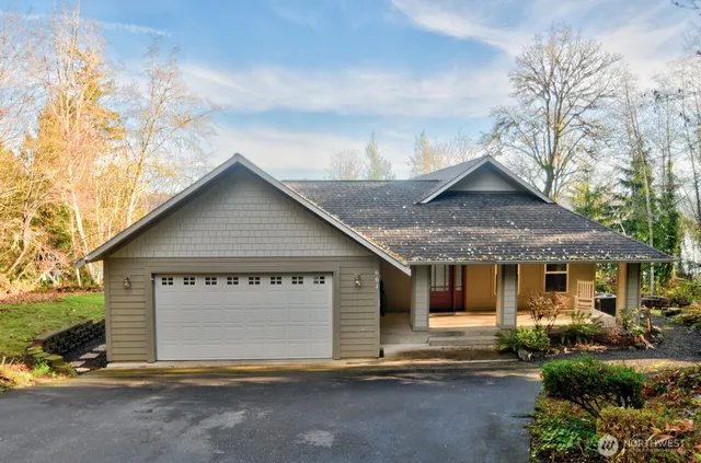 a view of a house with a yard and large tree