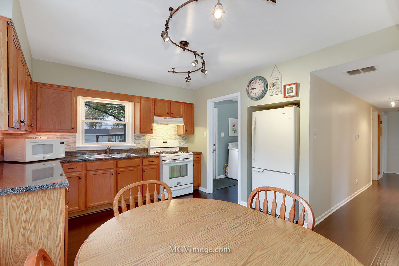 5830 108th Place Chicago Ridge, IL 60415 - Photo 11 of 28 a kitchen with stainless steel appliances granite countertop a refrigerator a stove a sink dishwasher a dining table and chairs with wooden floor