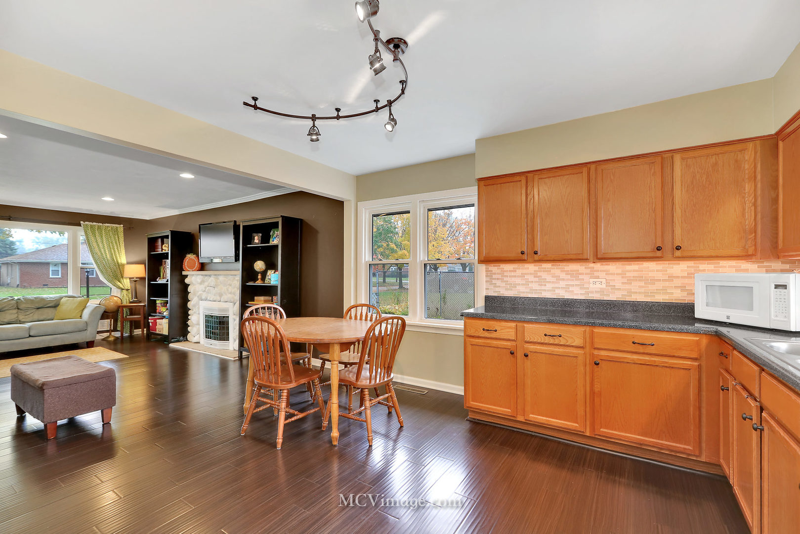 5830 108th Place Chicago Ridge, IL 60415 - Photo 12 of 28 a kitchen with stainless steel appliances granite countertop dining table chairs and wooden floor