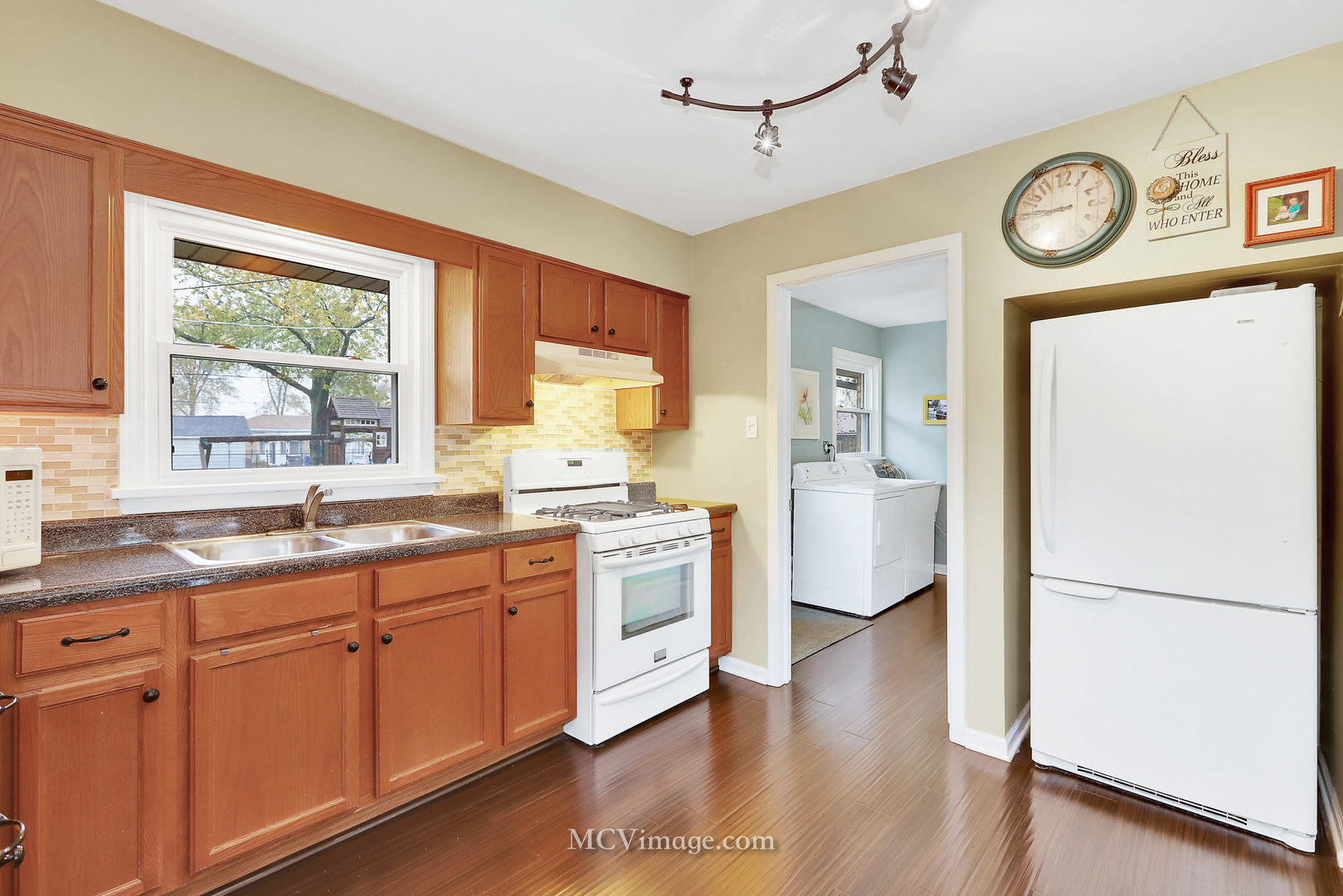 5830 108th Place Chicago Ridge, IL 60415 - Photo 14 of 28 a open kitchen with a refrigerator a stove top oven and a large window
