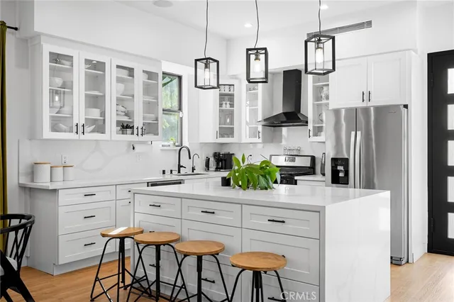 a kitchen with stainless steel appliances kitchen island granite countertop a refrigerator and a stove top oven