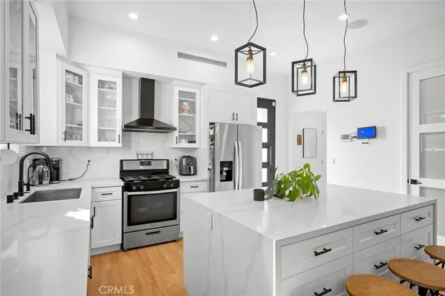 a kitchen with stainless steel appliances kitchen island granite countertop a sink a stove and a refrigerator