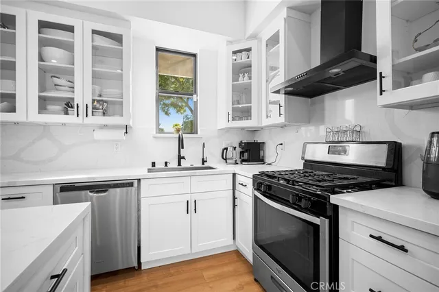 a kitchen with stainless steel appliances granite countertop a sink a stove and cabinets