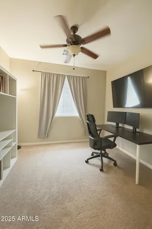 a living room with furniture and a ceiling fan