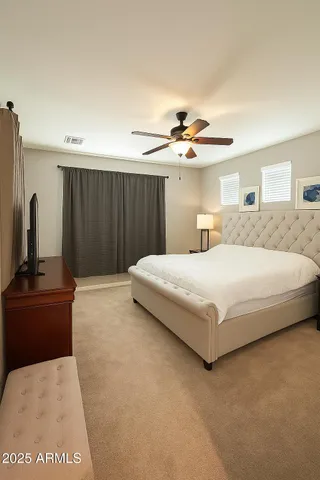 a bedroom with a large bed and a chandelier