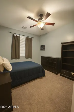 a bedroom with a bed and a ceiling fan