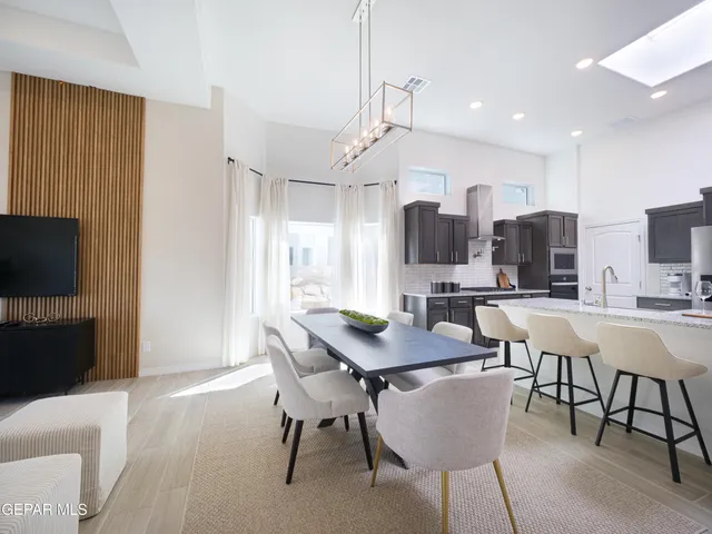 a kitchen with granite countertop a refrigerator a sink a stove a counter top space and cabinets