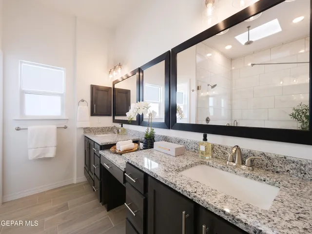 a bathroom with a granite countertop toilet sink and mirror
