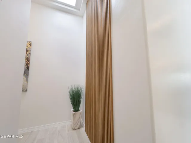 a view of a hallway with wooden floor and closet