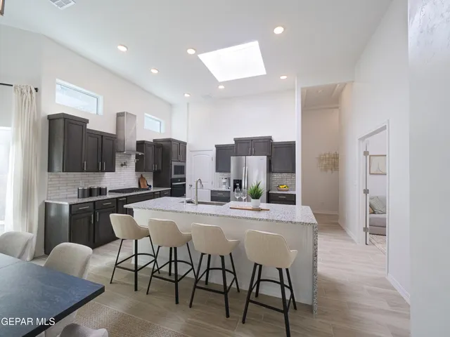 a kitchen with stainless steel appliances granite countertop a stove a sink and a refrigerator