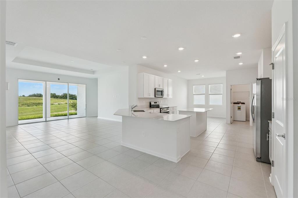 1672 Rider Rain Lane Apopka, FL 32703 - Photo 11 of 35 a view of a living room kitchen with stainless steel appliances granite countertop a sink and cabinets