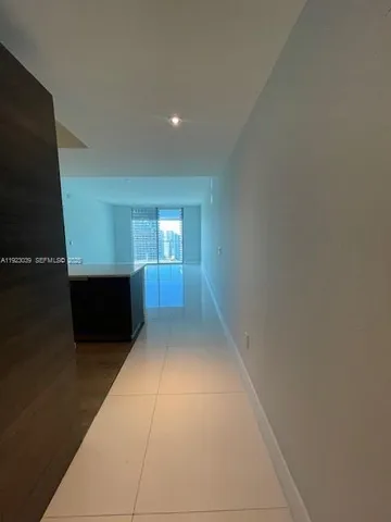 a kitchen with wooden floor and electronic appliances