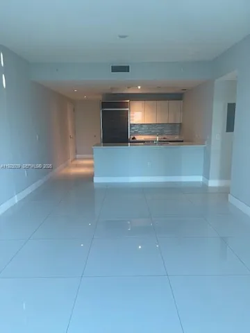 a view of a kitchen and an empty room