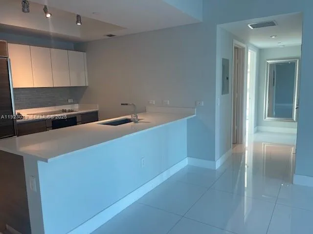 a kitchen with kitchen island a stove a sink and a refrigerator