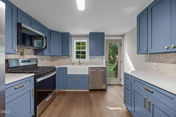 a kitchen with a refrigerator stove top oven and sink