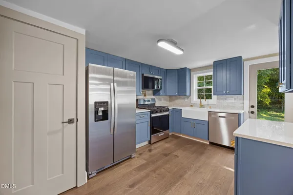 a kitchen with sink cabinets and wooden floor