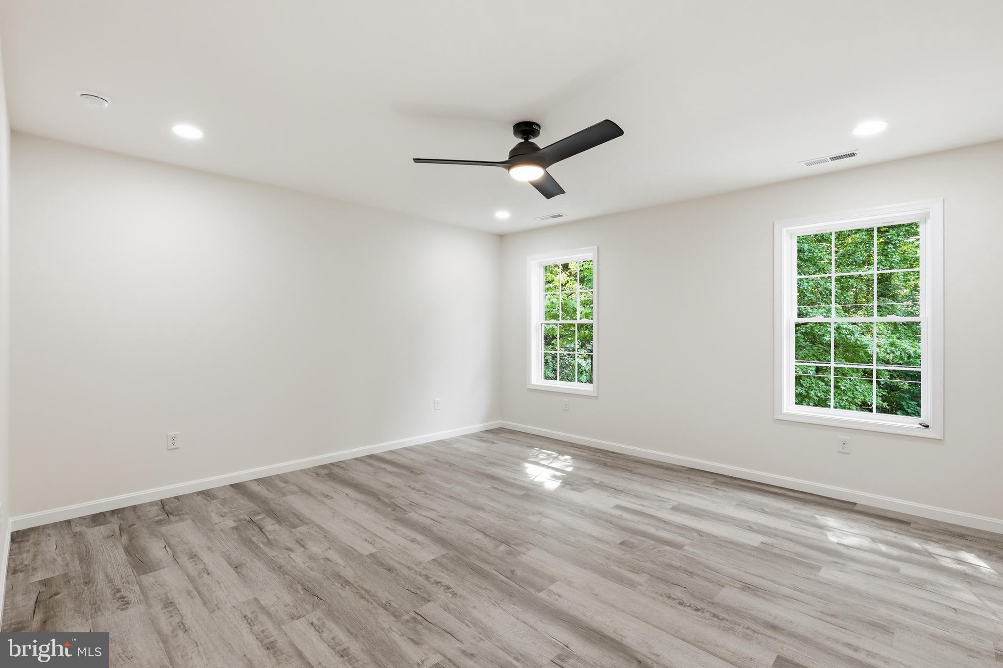 1354 College Road Dover, DE 19904 - Photo 25 of 46 an empty room with wooden floor ceiling fan and windows