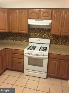 a stove top oven sitting inside of a kitchen