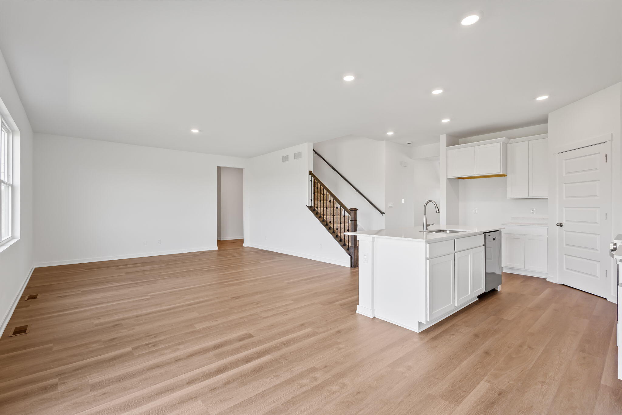 7883 West 105th Avenue Crown Point, IN 46307 - Photo 8 of 26 a view of an empty room with wooden floor and stairs