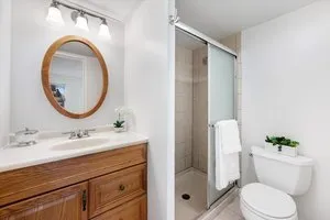 a bathroom with a sink a mirror a toilet and a shower