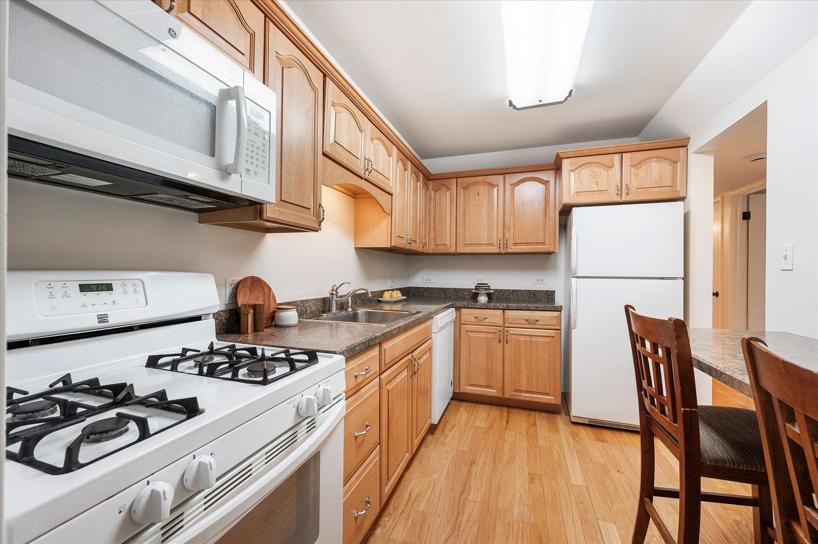 100 West Butterfield Road, Unit 101N Elmhurst, IL 60126 - Photo 10 of 27 a kitchen with stainless steel appliances granite countertop a stove a sink dishwasher and a refrigerator with wooden cabinets