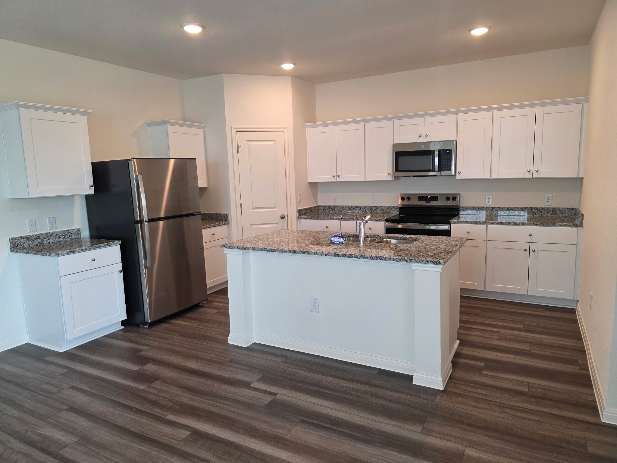 353 Enforcer Loop Jarrell, TX 76537 - Photo 4 of 21 Kitchen featuring appliances with stainless steel finishes, a sink, dark wood-style floors, white cabinets, and recessed lighting