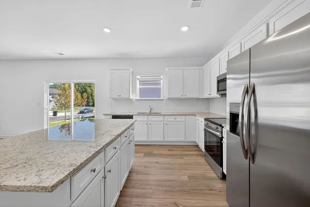 a kitchen with granite countertop a refrigerator sink and stove