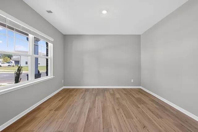 a view of a room with wooden floor and a window