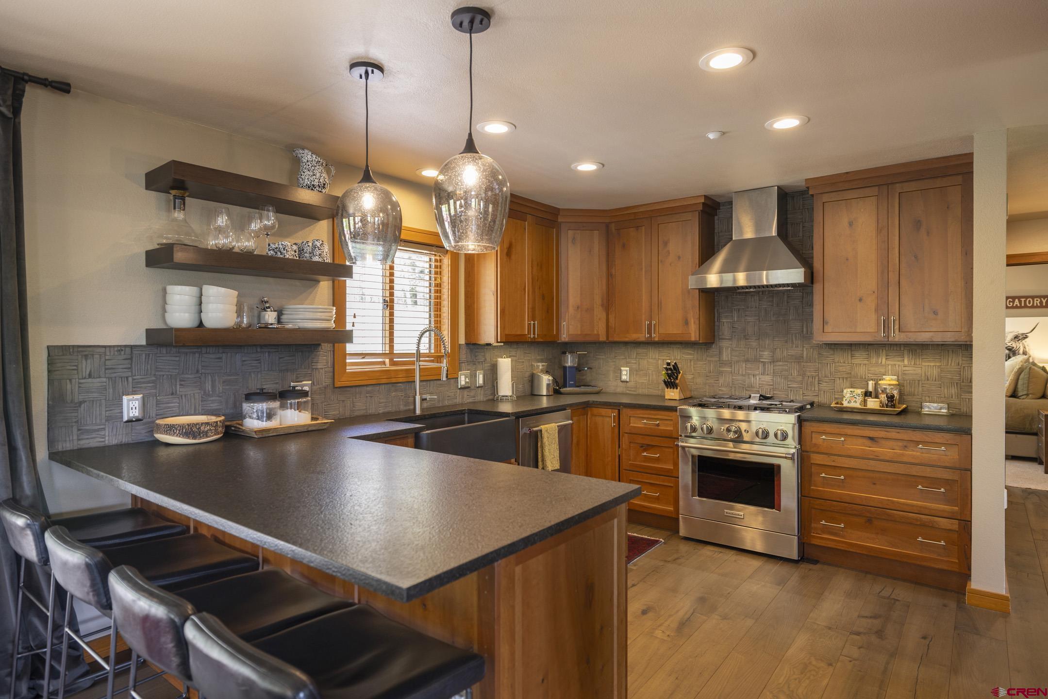 154 Falcon Ridge Road Durango, CO 81301 - Photo 16 of 42 a kitchen with stainless steel appliances granite countertop a sink a stove and a wooden floors