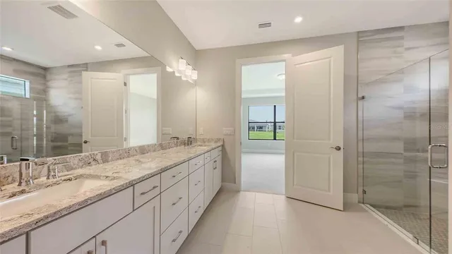 a bathroom with a granite countertop sink mirror and double