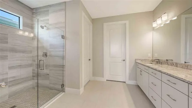 a bathroom with a granite countertop sink mirror and shower
