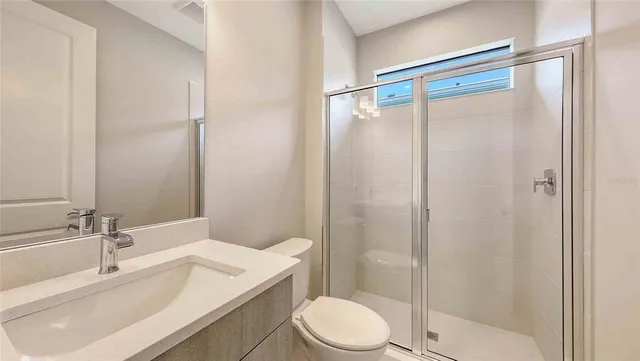 a bathroom with a sink a toilet and shower