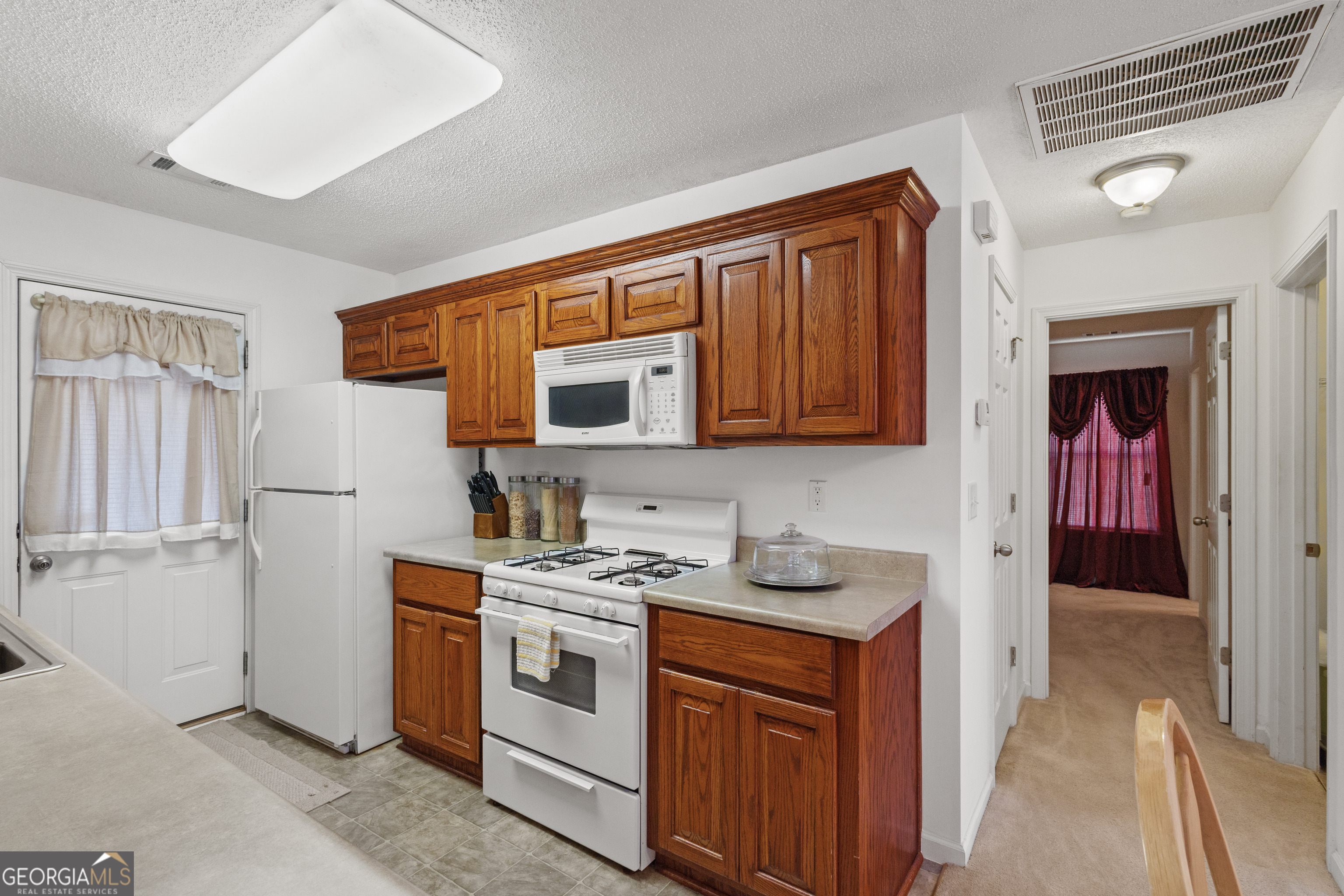 1275 Ross St Lane Macon, GA 31201 - Photo 10 of 20 a kitchen with stainless steel appliances granite countertop a sink stove and refrigerator
