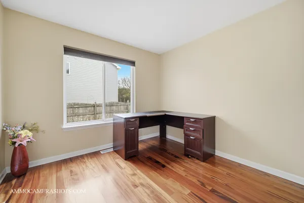 a view of an empty room with window and wooden floor