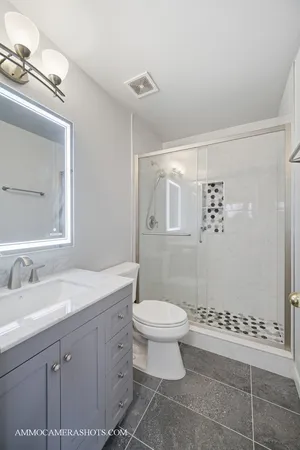 a spacious bathroom with a granite countertop sink a mirror and a shower
